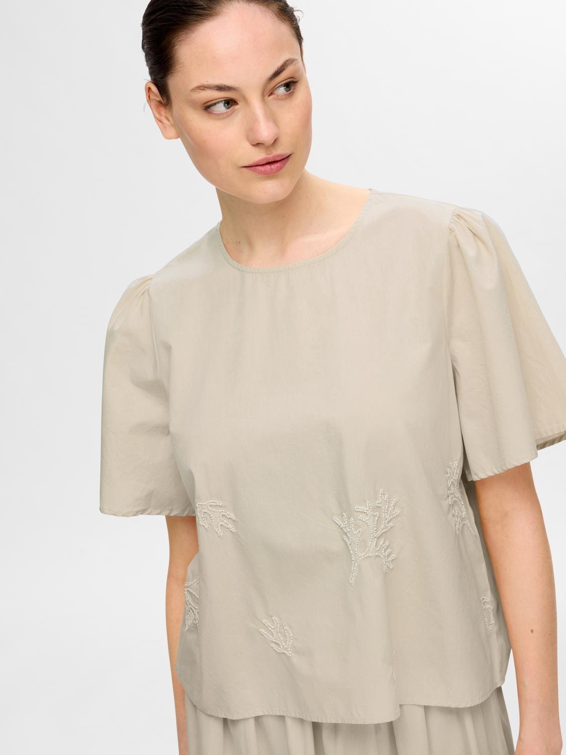 Beige top embroidered detail